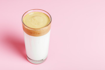  Dalgona coffee in a glass cup on a pink background. Minimalism, copy space