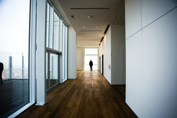 man staring view landscape from corridor in building warm colors