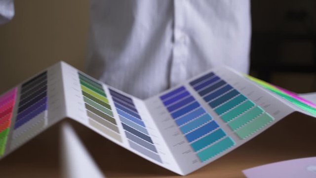 designer unfolds a palette on cardboard for color matching