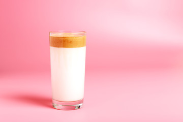  Dalgona coffee in a glass cup on a pink background. Minimalism, copy space