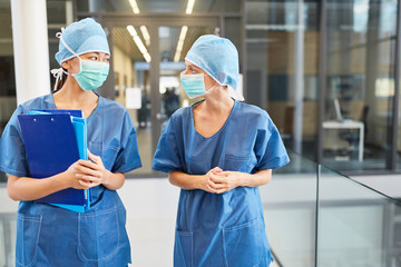 Two surgeons in blue surgical gown with surgical mask