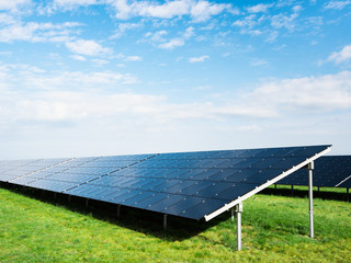 Photovoltaik Solaranlage an einem sonnigen Tag vor blauem Himmel mit vereinzelten Wolken - 345352352