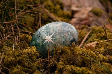 Easter painted blue egg with star on moss