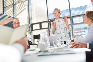 Ältere Referentin diskutiert mit dem Business Team