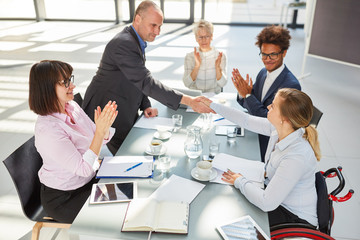 Geschäftsmann beim handshake mit Kollegin im Rollstuhl