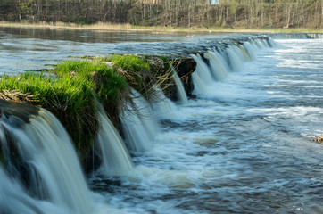 Beautiful waterfall in the river with green grass