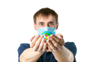 Close-up of a man's hands holding a globe, with images South America:Brazil, Ecuador, Bolivia, a man in a medical mask out of focus, dressed in a blue t-shirt, on a white background.  Coronavirus