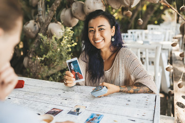 Woman is reading Tarot cards with a customer outdoors