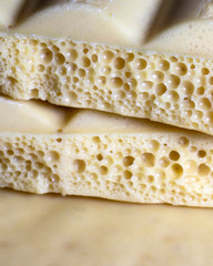 Background, texture of porous white chocolate close-up.