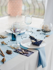 Prepared birthday table with paper elegant tableware for children party in blue colors. Baby shower day. Selective focus