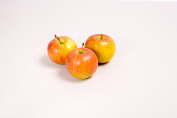 .three apples on a beige background are located in the center top view