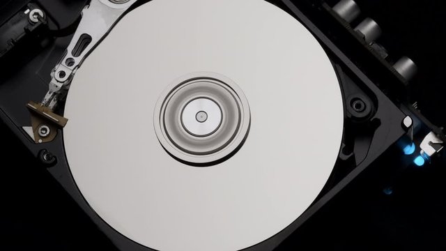 Macro, Close-Up of Computer Hard Disk Drive Spinning and Writing then Rotation Stop. Blue Lights Blinking. 4k 