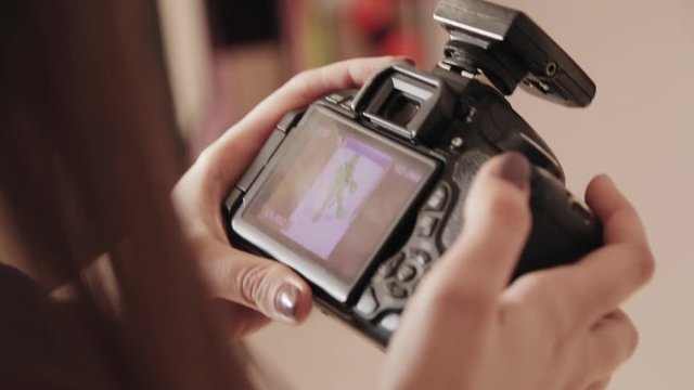 Photographer looks through photos on a DSLR camera
