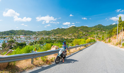 One person riding motorbike on winding road looking at view of gorgeous coast in the Phu Yen...