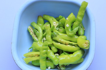 Removing dust from green chillies with a white background