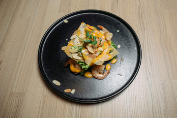 fried shrimp in white sauce with almonds on a black plate