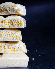 Broken bar of white chocolate on a black background. A delicious bar of milk chocolate. Selective focus