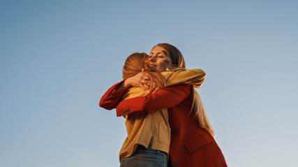 Low Angle Shot of Sweet Mother Hugging Her Young Daughter Victims of Some Terrible Accident. Both...