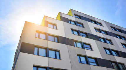 Modern apartment buildings on a sunny day with a blue sky. Facade of a modern apartment building. Glass surface with sunlight.
