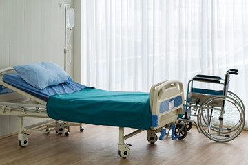 picture of bed in the ward in the hospital with wheelchair of the senior handicap patient that got sick from accident