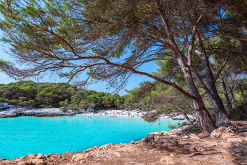 View of the famous beach Cala Turqueta. (Focus on foreground, people on the beach in blur). Menorca, Balearic islands, Spain