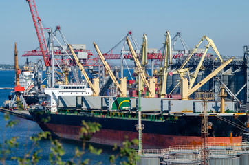 Port cargo crane loads a container onto a cargo ship in a seaport