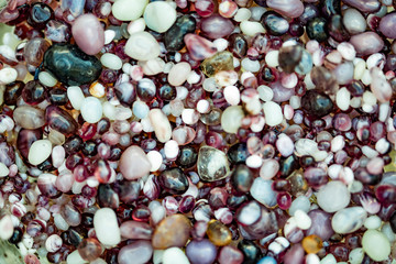 Pebbles on the beach washed by the intermittent waves of the sea