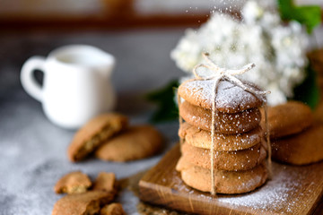Homemade oatmeal cookies on a wooden cutting board on old table background