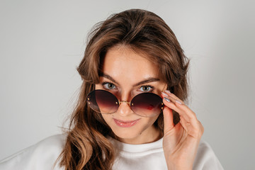 Beautiful young woman with big black glasses-close up portrait on white background