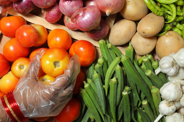 Indian Woman wearing gloves for hands consuming vegtables,indian market,asian vegetable market