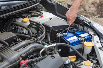 Man fixing car battery with wrench. Replacing car battery.