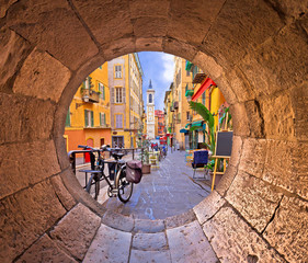 Nice colorful street architecture and church view through stone window