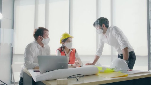 Group construction worker are meeting and brainstorm together at the workplace to discuss for new project during covid19 pandemic, Architect engineer teamwork wearing face mask while discuss together.