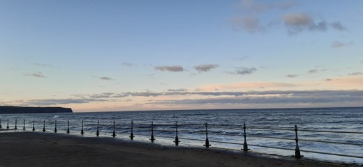 Naklejka premium Concrete railed promenade along Whitby beach at sunset