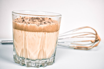 Milkshake kawowo-czekoladowy w szklance na białym tle