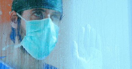 Medico guarda triste dalla finestra - obrazy, fototapety, plakaty
