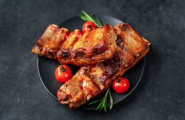 Grilled pork ribs with spices on a plate on a stone background