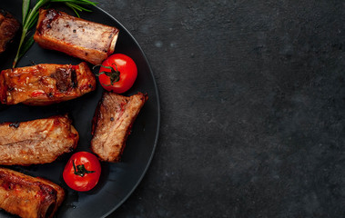 
Grilled pork ribs with spices on a plate on a stone background 
with copy space for your text