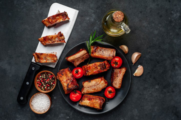
Grilled pork ribs with spices on a plate on a stone background 
with copy space for your text