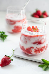 Strawberry shake with coconut milk served with slices of fresh strawberries and mint leaves. Healthy food and drink concept. vertical image