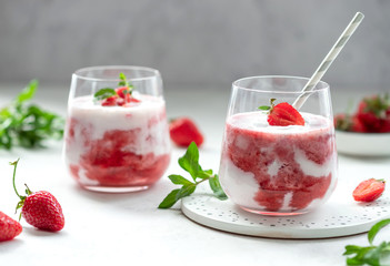two glasses of milkshake with fresh strawberries and mint. healthy summer detox drink. Gray background. horizontal image.