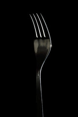 Silhouette of a profiled fork with light and with a black background