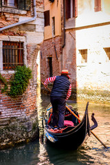 Fototapeta na wymiar Gondolier carry tourists on the beautiful canals of Venice .