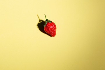 red strawberry on a sheet of yellow canton
