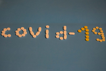 inscription covid -19 made of pills on a blue background