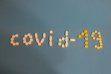 inscription covid -19 made of pills on a blue background