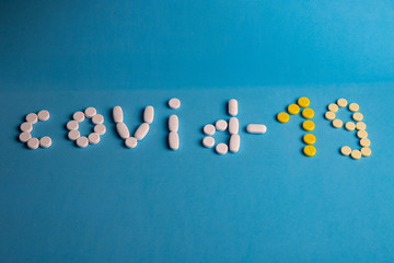inscription covid -19 made of pills on a blue background