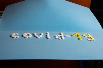 inscription covid -19 made of pills on a blue background