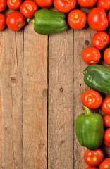 Fresh tomato and pepper on wooden background. Top view with copyspace. Vertical photo.