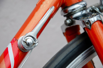Bicycle repair. Wheel and shiny axle of chrome steel of an old road bike closeup. Retro bike. Red iron fork. Quick Release.